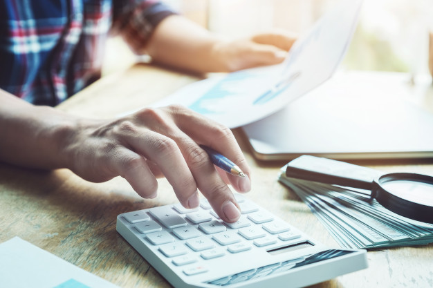 Image d'un chef d'entreprise en train de comparer les avantages de la location de véhicules utilitaires par rapport aux coûts de détention de ses propres véhicules